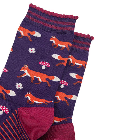 Pair of socks with fox and mushroom pattern on a white background