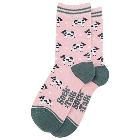 Pink socks with cow pattern and green accents on a white background