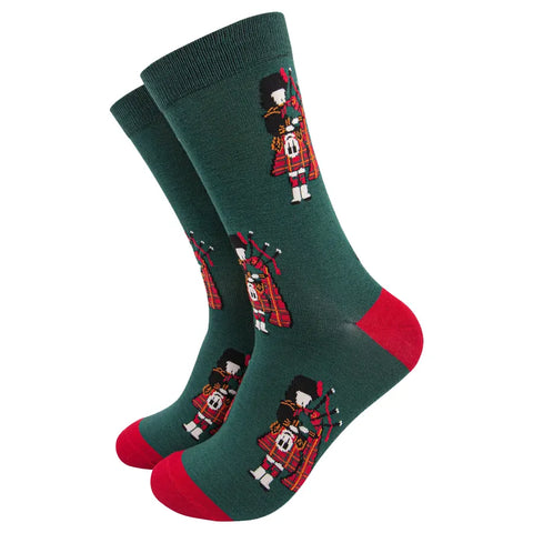 Green socks with bagpipe player design on a white background