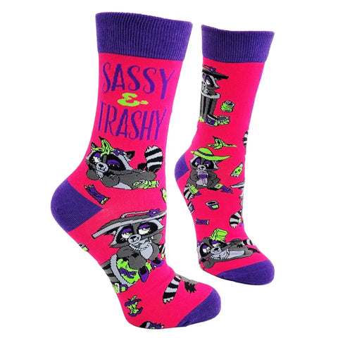 Pink socks with purple accents featuring a raccoon design and 'Sassy & Trashy' text on a white background.